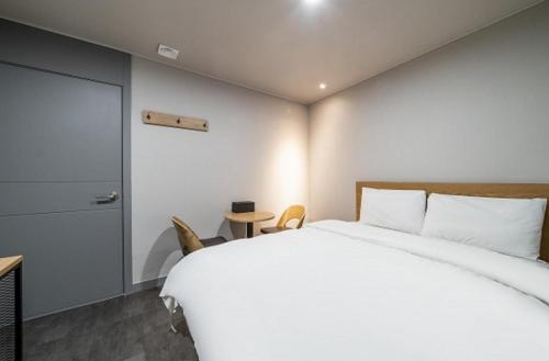 a bedroom with a large white bed and a door at Hotel Remi in Seoul