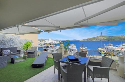 a patio with a table and chairs and a view of the water at Aquaemaris Apartment in La Maddalena