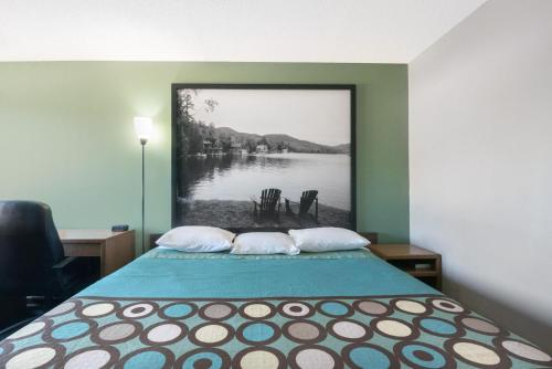 a bedroom with a bed with a picture of a lake at Super 8 by Wyndham Milbank SD in Milbank