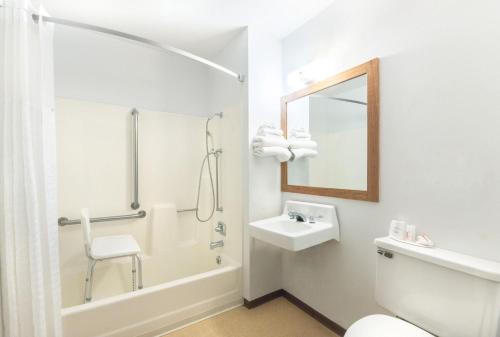 a bathroom with a toilet and a sink and a mirror at Super 8 by Wyndham Milbank SD in Milbank