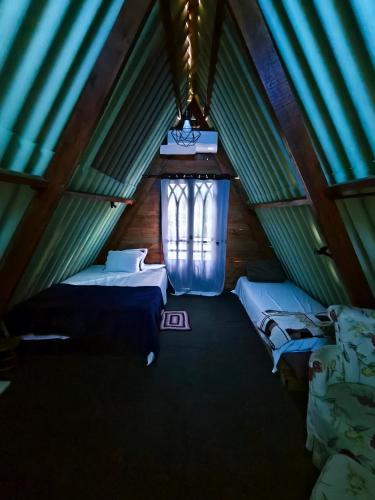 a room with two beds and a window in a tent at Chalé no Plantar em Casa in São Roque