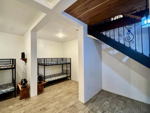 a room with two bunk beds and a staircase at Van Kouwenhoven Hostel in Diriamba