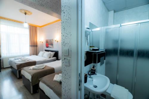 a hotel room with two beds and a sink and a bathroom at Golden Horn Park Hotel in Istanbul