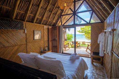 a bedroom with a bed and a view of the ocean at Hotel Isla Mucura in Isla Mucura