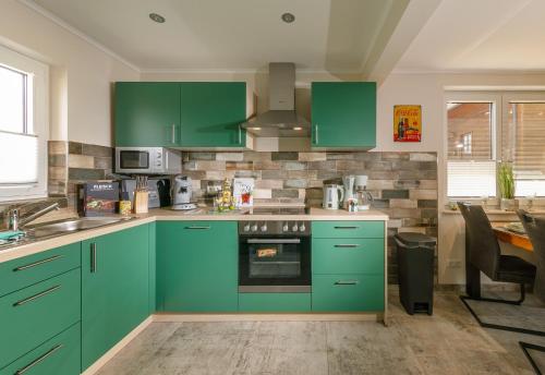 a kitchen with green cabinets and a sink at Premium-Plus-Ferienhaus Havanna Select in Hasselfelde