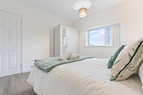 a white bedroom with a bed with a stuffed animal on it at Zuri Luxe Escape - Wolverhampton in Bilston