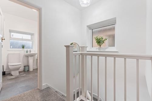 a white bathroom with a toilet and a sink at Zuri Luxe Escape - Wolverhampton in Bilston