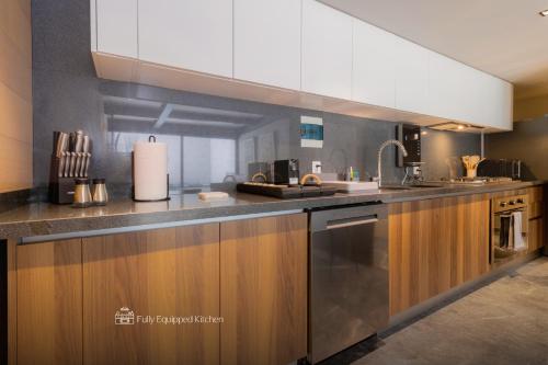 a kitchen with wooden cabinets and stainless steel appliances at Capitalia Moliere Masaryk in Mexico City