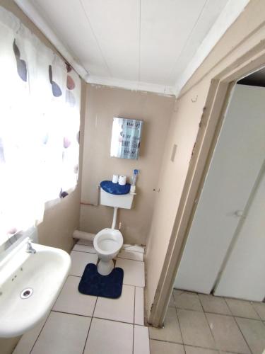 a bathroom with a toilet and a sink at affordable room rustenburg in Kroondal