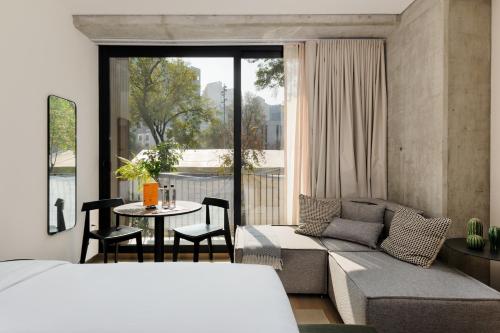 a bedroom with a bed and a table and a couch at Sullivan by Wynwood House in Mexico City