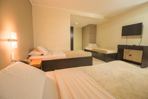 ein Hotelzimmer mit 2 Betten und einem Flachbild-TV in der Unterkunft Asia Stars Hotel in Tacloban