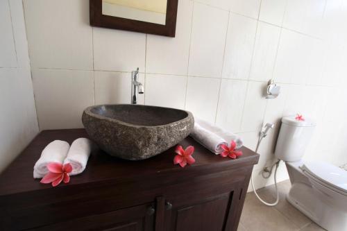 a bathroom with a sink on a counter with towels at Uma Budhas in Ubud