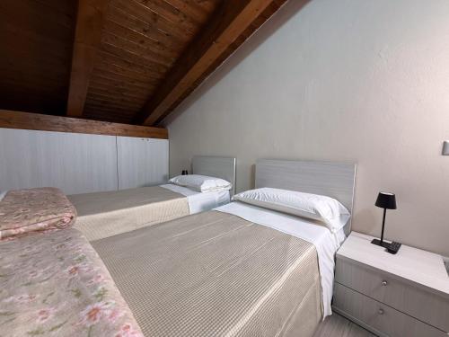 a bedroom with two beds and a wooden ceiling at La Dimora Certosina in Padula
