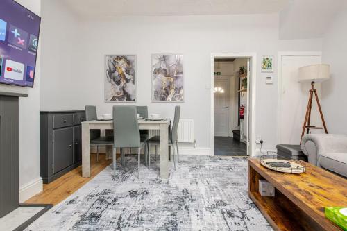 a living room with a table and a couch at Cosy Brierfield house with fireplace and parking in Brierfield