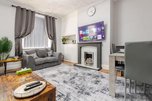 a living room with a couch and a fireplace at Cosy Brierfield house with fireplace and parking in Brierfield