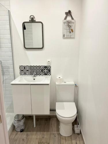 a white bathroom with a toilet and a sink at Agreable studio proche du circuit du Mans in Arnage