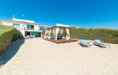 two chairs and a gazebo on a sandy beach at Sa Platja in Playa de Muro