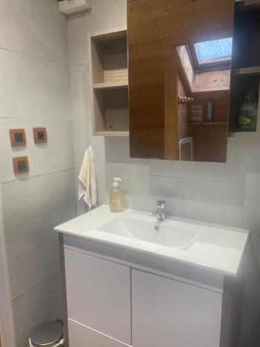 a white bathroom with a sink and a mirror at Gite l'Ancolie in Marignier