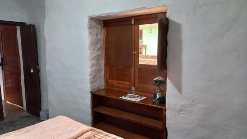 a bedroom with a wooden cabinet and a bed at Casa turística la Nativa in Puracé