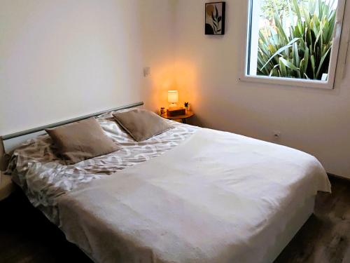 a bedroom with a large white bed with a window at Tamaris Abba in Talmont