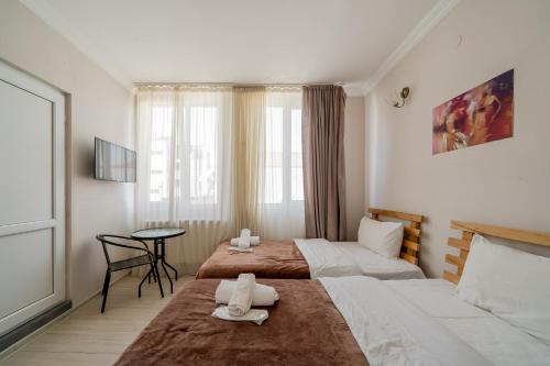 a hotel room with two beds and a table at Tato in Tbilisi City
