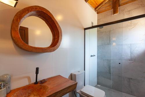 a bathroom with a sink and a shower with a mirror at Casa de veraneio na Itapeva in Torres
