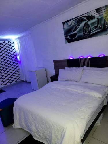 a bedroom with a bed with a car on the wall at affordable room rustenburg in Kroondal