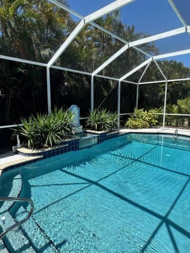 a swimming pool with a clear blue water in front of a building at Villa Paloma in Cape Coral