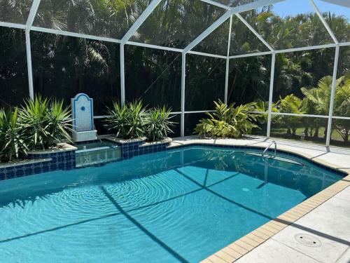 a swimming pool in front of a building with a house at Villa Paloma in Cape Coral