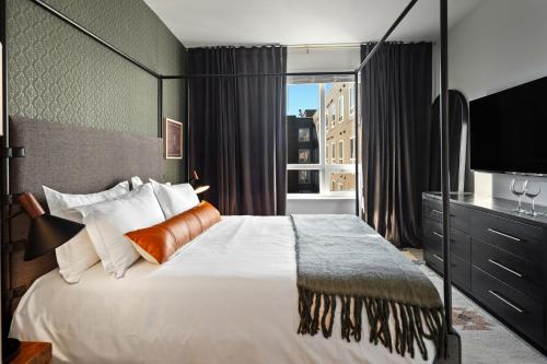 a bedroom with a large bed and a large window at Hyatus Luxury Residences Boston Everett Signature Collection in Everett