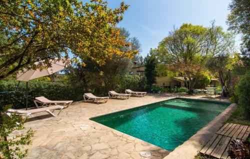 a swimming pool with chaise lounges and chairs next to a house at Can Pintad in Ruberts