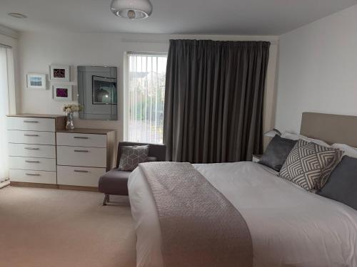 a bedroom with a bed and a dresser and a window at Seaview West Coast - Exceptional - 2 Bedrooms Sleeps 5 -Stunning Sea Views - 500 metres to Beach in Bournemouth