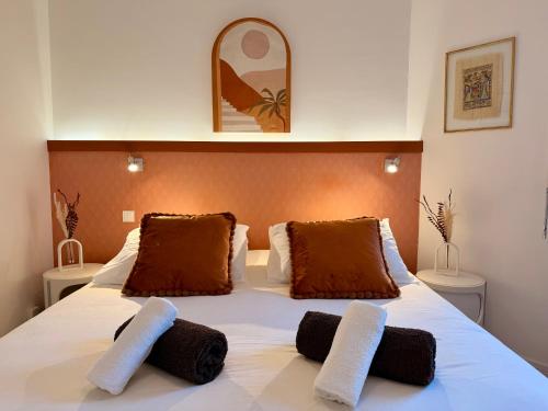 a bedroom with a white bed with two towels on it at Le Baloo vue sur mer in Ploemeur