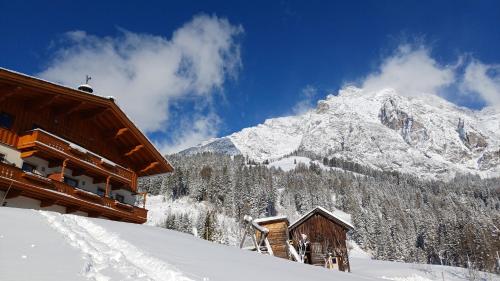 a ski lodge with a snow covered mountain in the background at Riedlhof - Leogang in Leogang
