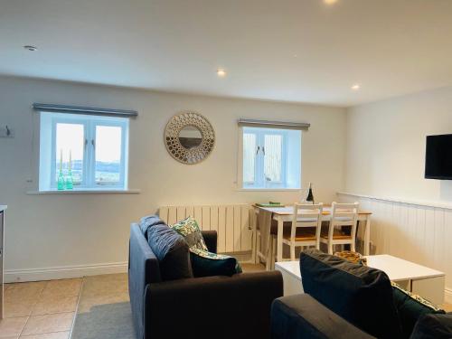 a living room with two couches and a table at The Mill Stylish Rural Apartment with Beautiful Views in Welsh Newton Common