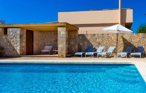 a swimming pool with chairs and an umbrella at Ca Nostra in Cala Millor