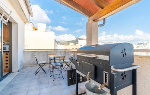 a grill on a balcony with a table and chairs at Atico Roger De Flor in Port de Pollensa