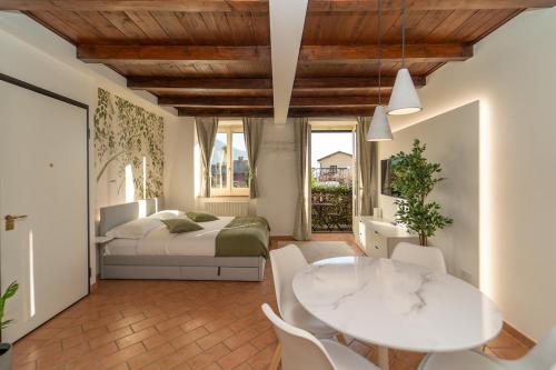 a bedroom with a bed and a table and chairs at Bright apartment with private garage in Cernobbio