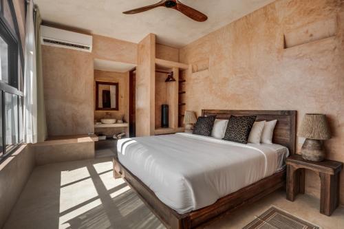 a bedroom with a bed and a ceiling fan at Coco Lou - Private Villa with Rooftop Pool in Holbox Island