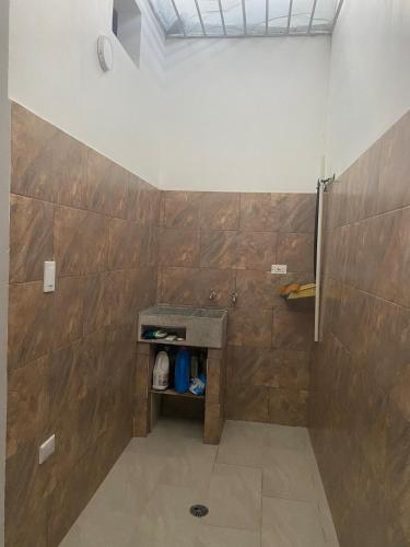 a bathroom with a shower with wooden walls at Tres Palmas Apartamento in Carmen de Apicalá
