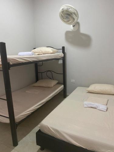 a room with two bunk beds and a fan at Tres Palmas Apartamento in Carmen de Apicalá