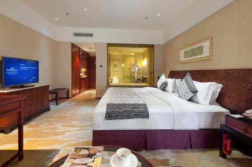 a hotel room with a large bed and a television at Howard Johnson Conference Resort Chengdu in Dujiangyan