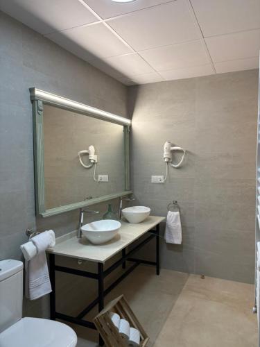 a bathroom with two sinks and a large mirror at La Ermita Casa Rural in Benablón