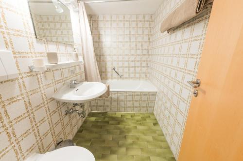 a small bathroom with a sink and a toilet at T13 Ferienwohnungen Schenk in Oberstdorf