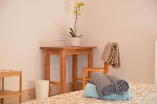 a room with a bed and a table and towels at Joz Une Halte in Saint-Antoine