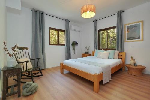 a bedroom with a bed and a chair in it at Lila in Bet Leẖem HaGelilit