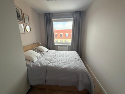 a small bedroom with a bed and a window at Apartament Przy Palmiarni in Wałbrzych