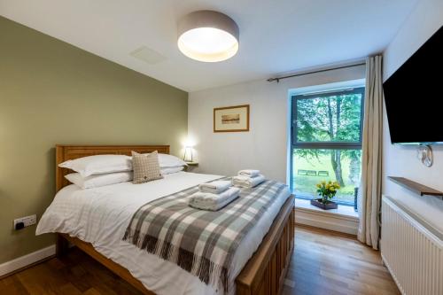 a bedroom with a large bed and a window at Calder apartment Raven Wing in Fort Augustus