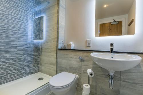 a bathroom with a sink and a toilet and a shower at Calder apartment Raven Wing in Fort Augustus
