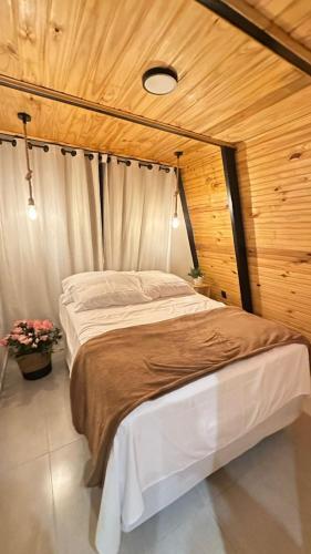 a large bed in a room with a wooden wall at Fabulosas da Serra in Monte das Gameleiras